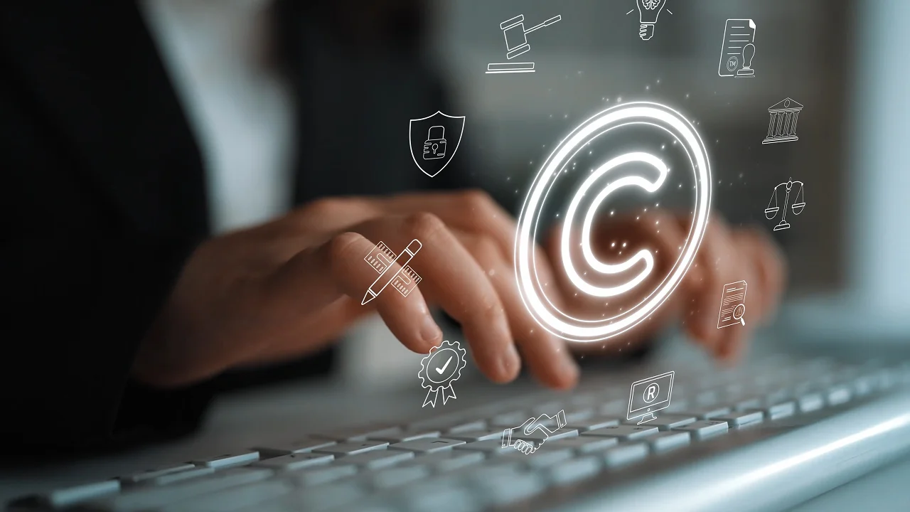 a person's hands are shown typing on a computer keyboard with a glowing, digital copyright symbol and various smaller legal and security icons overlaid in the foreground.