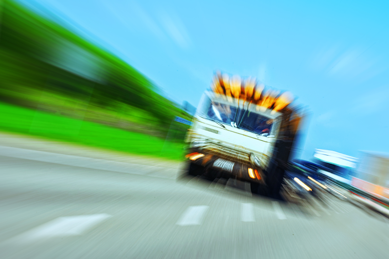Truck in a blur on the road in motion. The danger of a collision or emergency situation. Violation of rules by truckers