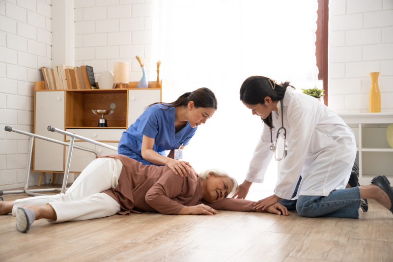 Asian caregiver help senior female from falling on the ground at home