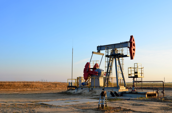 Oil drilling derricks at desert oilfield. Crude oil production from the ground.