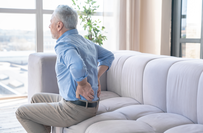 Senior caucasian old elderly man suffering from back pain at home. Rheumatism, ache, health problems.