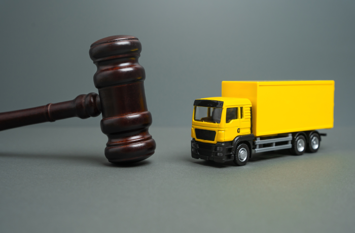 Yellow truck and judge's gavel. Court case. New laws and acts. Restrictions and regulations.