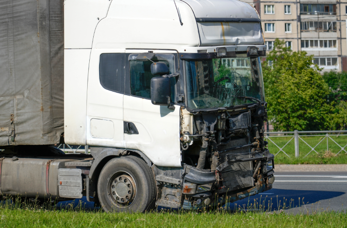 Truck after a head-on accident with a pole on a city street, the driver's cabin is crumpled
