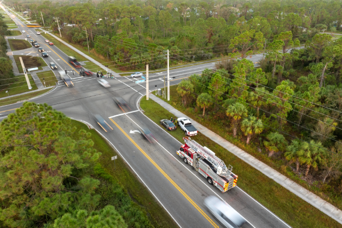 First responders responding to car accident site on American street. Emergency services helping victims of vehicle crash on road in USA.